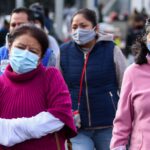 Personas con cubrebocas, chamarras y guantes transitan por el primer cuadro de la ciudad